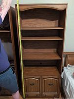 Front view of full bookcase showing adjustable shelves and lower cabinet