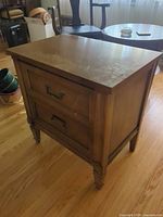 Front and side view of nightstand showing overall form and drawers