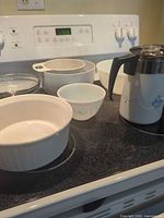 Six white ceramic bowls, clear Pyrex bowl, Blue Cornflower percolator on stovetop
