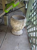 Overall view of concrete planter urn showing Greek key band, fluted base, weathered finish and size context