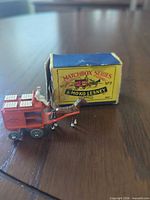 Toy wagon hitched to horse beside original box, front three-quarter view