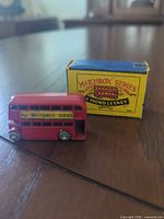 Left front side view of bus alongside original box