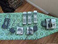 Full set laid out: 3 handsets, base, 2 cradles, 3 adapters, wall bracket