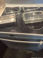 Four loaf pans on stovetop – three glass with lids, one metal