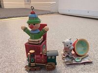 All three Christmas ornaments grouped together: clown jack-in-the-box, 1991 locomotive, and cat with broken ball