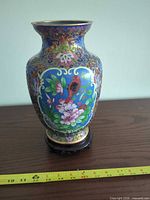 Front view of cloisonné vase on stand with tape measure indicating height