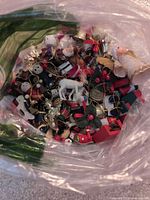 Clear bag filled with assorted miniature Christmas ornaments of various shapes, colors and materials