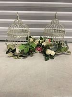 Front view of both metal birdcage decorations with flowers
