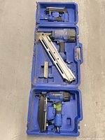 Three Campbell Hausfeld framing nailers in opened carry cases