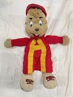 Front view of Alvin plush hand puppet showing red suit, yellow A, stuffed feet