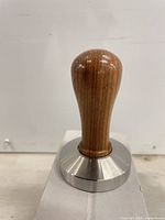 Side profile of wooden-handled coffee tamper