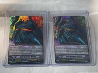 Front view of both Dark Revenger, Mac Lir cards in sleeves and top loaders