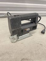Left side view of Black & Decker corded electric jigsaw showing body, handle and cord