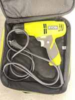 Drill inside open carrying case showing full tool and cord