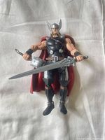 Front view of Thor figure holding hammer and sword