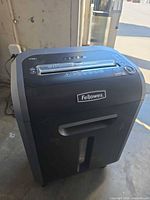 Front angled view showing Fellowes logo, paper entry slot, bin window, overall condition