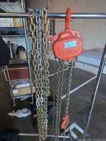 Front view of NiT red hoist body with hanging chains and hook