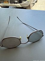 Front view of Calvin Klein metal oval sunglasses showing green-tint lenses