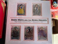 Overall view of matted display with five Disney Snow White character cards