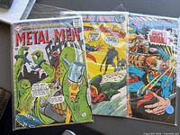 Three comic books in sleeves: Metal Men, World's Finest, Superman