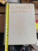 Front cover with measuring tape showing height (~14 in) and beige cloth binding