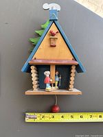 Front view of chalet music box showing figures, pull cord and overall design