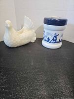 Dove candle beside Opaline jar