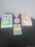 Group shot of three boxed card decks, quartz rock, and dyed agate slice