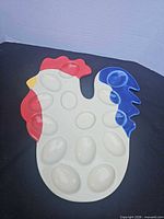 Front of chicken-shaped deviled egg tray showing 12 wells and paint colors