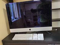 Front view of 27-inch Apple iMac with keyboard on desk