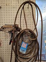 Rubber V-belts hanging on pegboard, Dayco Top Cog tag visible