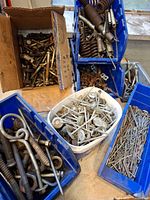 Overview of multiple bins showing mixed bolts, hooks, springs, screws and washers