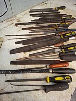 Wide view of assorted files and rasps laid out on workbench