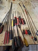 Full group of screwdrivers and pickup tools laid out on workbench