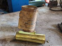 Torn wrapper and brass shim stock roll showing label with width and length