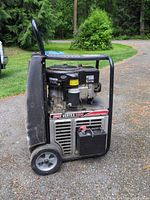 Front left view showing Coleman Vertex 5500 decal, control panel, wheels, battery, overall wear