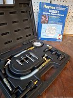 Full view of compression tester kit in case and Haynes manual