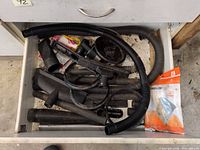 Drawer view with hose, metal tubes, various attachments, Electrolux bag pack