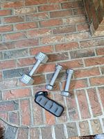 Three dumbbells and ankle weight on brick surface