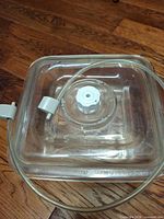 lid with valve and attached hose on wooden floor