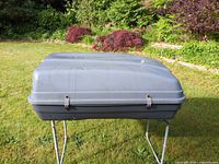 Closed gray rooftop cargo box on stand