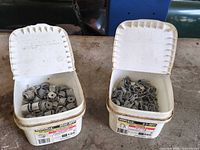 Two tubs of loose metal connectors and staples