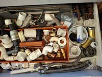 Drawer containing mixed PVC brass copper fittings hoses and gaskets