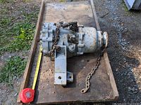 Top view of marine gearbox on wooden cart with chain and bracket visible