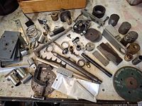 Top view of entire assortment showing pulleys, bushings, plates, clamps, rods and abrasive wheel
