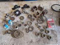 Overview of all items on workbench: pillow blocks, clevis brackets, loose bearings, caster, hardware