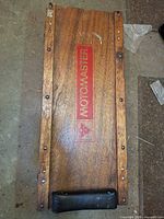 Top view showing MotoMaster logo, wood surface, missing wheels