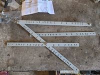 Pantograph arms laid out with clamp bag and instruction sheet visible