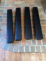 Four black Samsung surround speakers on floor