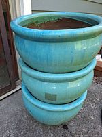 Stacked view of all three turquoise glazed planters showing exterior finish and rim profile